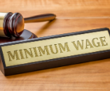 Minimum wage sign on wooden desk with gavel