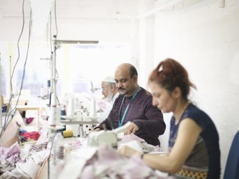 Two men and a women sewing clothes