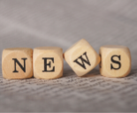 Four brown die spelling news on page of book