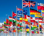 Group of flags from world nations against blue sky