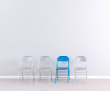 For chairs against a white wall three white and one blue.png